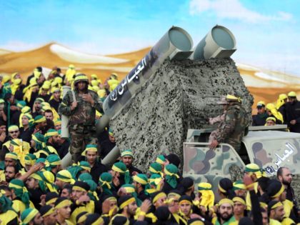 Members of Lebanon's powerful Shiite movement Hezbollah parade with a mock missile launche