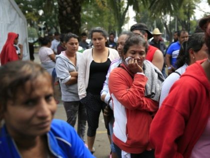 Women and men stand in separate lines to sort through donated clothing at a sports complex sheltering various migrant caravans trying to reach the U.S. border, in Mexico City, Tuesday, Nov. 13, 2018. While thousands in one caravan continued moving north through Nayarit state on Tuesday, over 1,000 migrants from …