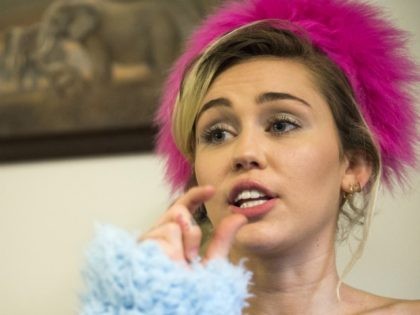 Miley Cyrus talks to students while campaigning for democratic presidential nominee Hillary Clinton, at George Mason University in Fairfax, Va. Saturday, Oct. 22, 2016. (AP Photo/Molly Riley)
