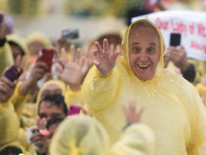 Pope Francis (R) wears a plastic poncho as he waves to well wishers after a mass in Tacloban on January 17, 2015. Pope Francis will spend an emotional day in the Philippines on January 17 with survivors of a catastrophic super typhoon that claimed thousands of lives, highlighting his concern …