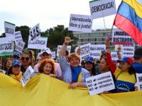 Venezuelans living in Spain shout slogans as they protest in support of the Venezuelan opposition during a demonstration in Madrid on May 1, 2019. - Hundreds of Venezuelans rallied in central Madrid in support of their country's self-proclaimed leader Juan Guaido, as riots broke out in faraway Caracas. (Photo by …