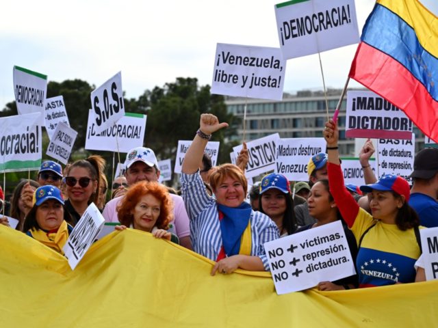 Venezuelans living in Spain shout slogans as they protest in support of the Venezuelan opp