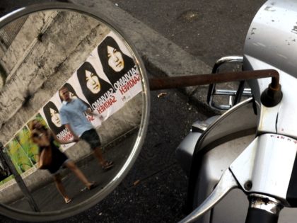 eople walking by posters of Iranian Sakineh Mohammadi-Ashtiani which read "save Sakineh" a