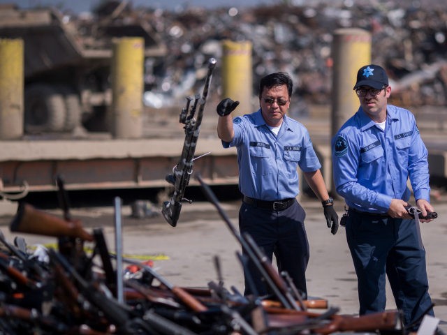 Deputies toss guns onto a pile of approximately 3,500 confiscated weapons to be destroyed at Gerdau Steel Mill under supervision of the Los Angeles County Sheriffs Department and other law enforcement agencies on July 19, 2018 in Rancho Cucamonga, California. The weapons were seized in criminal investigations, probation seizures and …