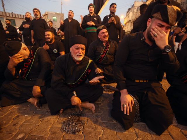 Iraqi Shiite Muslim men cry in the capital Baghdad's mostly Shiite neighbourhood of Kadhimiya on the eve of Ashura on September 9, 2019. - The religious commemoration of Ashura, which includes a ten-day mourning period starting on the first day of Muharram on the Islamic calendar, commemorates the seventh-century slaying …