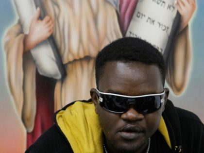 A Sudanese man sits in front of a Jewish religious mural during a joint wedding ceremony for three refugee couples from Sudan in Tel Aviv, Israel, Monday, Feb. 16, 2009. Thousands of Africans, including hundreds from war-torn Sudan have sought refuge in recent years in the Jewish state, arriving across …