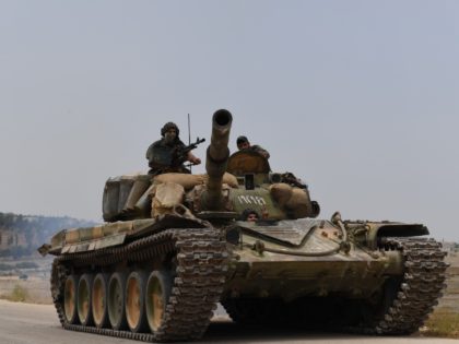 A tank belonging to the Syrian regime forces drives on a road leading to the town of Jalamah in Syria's Hama governorate during clashes with jihadists on June 8, 2019. - Last week, the jihadists and allied rebels launched a counterattack against regime forces in the northwest of Hama province, …
