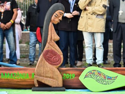 A wooden carved sculpture of a pregnant woman and a pirogue's model, symbolizing the stakes within the only way to travel on the Amazon rivers, is pictured during a procession of indigenous leaders, prelates and people participating in the Special Assembly of the Synod of Bishops for the Pan-Amazon Region, …