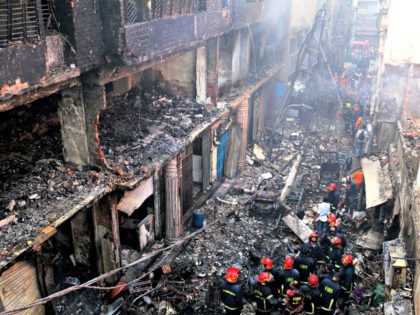 In this, Thursday, Feb. 21, 2019 file photo, locals and firefighters gather around buildings that caught fire late Wednesday, Feb. 20 in Dhaka, Bangladesh. After more than 1,100 people died when a garment factory complex collapsed in Dhaka, Bangladesh authorities imposed more stringent safety rules. But corruption and lax enforcement …