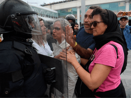 TOPSHOT - Protesters clash with a Spanish policeman outside El Prat airport in Barcelona on October 14, 2019 as thousands of angry protesters took to the streets after Spain's Supreme Court sentenced nine Catalan separatist leaders to between nine and 13 years in jail for sedition over the failed 2017 …
