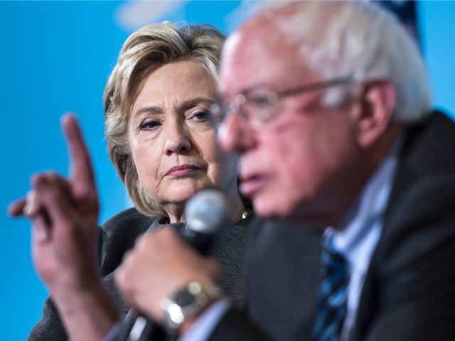 Democratic presidential nominee Hillary Clinton listens as Senator Bernie Sanders (I-VT) speaks during an event at University of New Hampshire September 28, 2016 in Durham, New Hampshire. / AFP / Brendan Smialowski (Photo credit should read BRENDAN SMIALOWSKI/AFP/Getty Images)