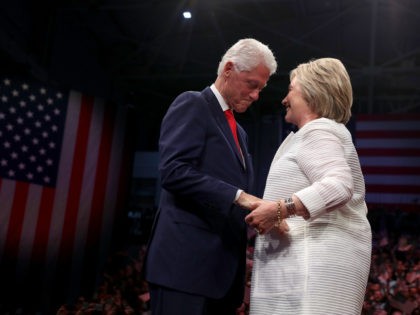 Democratic presidential candidate former Secretary of State Hillary Clinton (R) and her husband former U.S. president Bill Clinton embrace during a primary night event on June 7, 2016 in Brooklyn, New York. Hillary Clinton surpassed the number of delegates needed to become the democratic nominee over rival Bernie Sanders with …