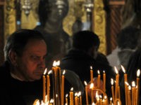 A Bosnian Orthodox Christian man lights a candle as she attends a Christmas morning religious service at the Orthodox Congregation Church in Sarajevo, on January 7, 2011. Bosnian Orhodox believers observe the Julian calendar, thus celebrating the birth of Jesus Christ on January 7. AFP PHOTO / ELVIS BARUKCIC (Photo …