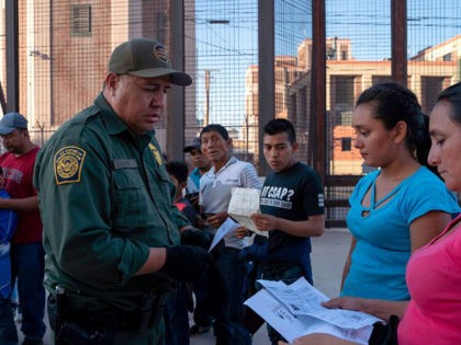 US Customs and Border Protection agent checks documents of a small group of migrants, who crossed the Rio Grande from Juarez, Mexico, on May 16, 2019, in El Paso, Texas. - About 1,100 migrants from Central America and other countries are crossing into the El Paso border sector each day. …