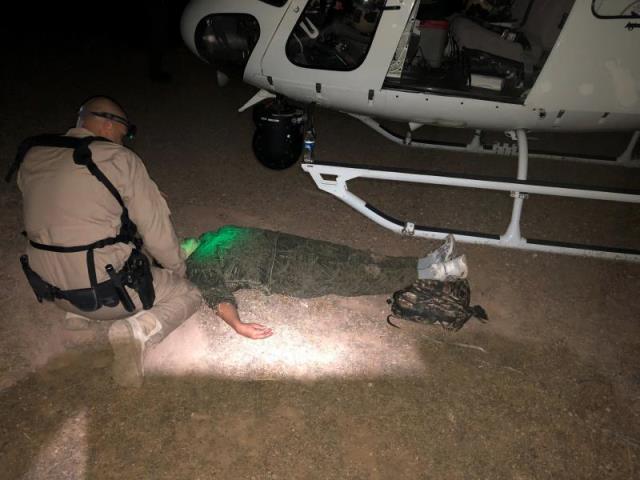 A U.S. Border Patrol agent working with a CBP Air and Marine Operations aircrew provides emergency medical care for a Honduran woman who collapsed in the desert. (Photo: U.S. Customs and Border Protection/Air and Marine Operations)