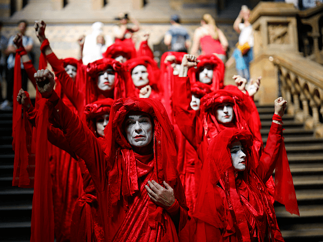 TOPSHOT - Extinction Rebellion climate change activists in red costume attend a mass "die in" in the main hall of the Natural History Museum in London on April 22, 2019, on the eighth day of the environmental group's protest calling for political change to combat climate change. - Climate change protesters who have brought parts of London to a standstill said Sunday they were prepared to call a halt if the British government will discuss their demands. Some 963 arrests have been made and 42 people charged in connection with the ongoing Extinction Rebellion protests. (Photo by Tolga Akmen / AFP) (Photo by TOLGA AKMEN/AFP via Getty Images)