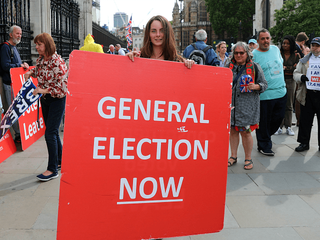 Protestors hold placards near the Houses of Parliament in central London on September 5, 2019. - UK Prime Minister Boris Johnson called Thursday for an early election after a flurry of parliamentary votes tore up his hardline Brexit strategy and left him without a majority. (Photo by ISABEL INFANTES / …