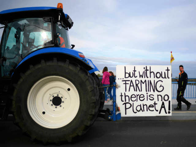 A tractor with a sign reading "...but without farming there is no planet A" stands on the