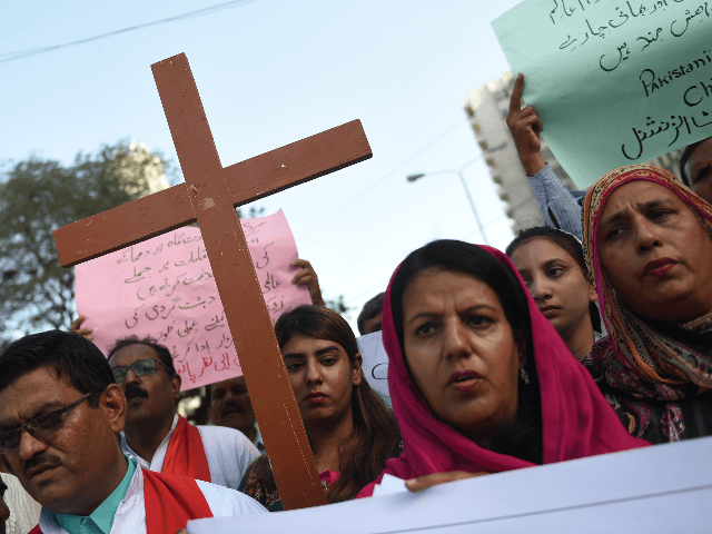 Pakistani Christians hold placards and cross during a protest in Karachi on April 27, 2019