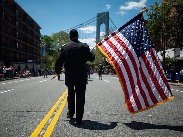 A veteran carries an American flag as he marches on the street May 27, 2019 during the 152nd Memorial Day Parade in the New York City borough of Brooklyn. - The Kings County Parade is one of the oldest Memorial Day Parades in the nation. (Photo by Johannes EISELE / …