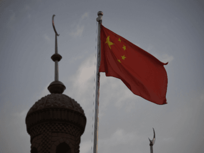 This photo taken on June 4, 2019 shows the Chinese flag flying over the Juma mosque in the restored old city area of Kashgar, in China's western Xinjiang region. - While Muslims around the world celebrated the end of Ramadan with early morning prayers and festivities this week, the recent …