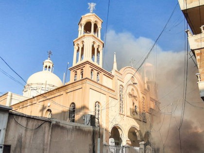 People gather at the scene of a car bomb explosion outside the Syriac Orthodox Church of t