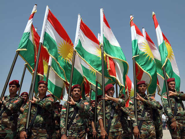 Members of the Iraqi Kurdish Peshmerga stand holding flags of Iraq's autonomous Kurdistan region a training session by German military officers during the German Defence Minister's visit at a facility on the outskirts of Arbil, the capital of the autonomous region, on August 21, 2019. (Photo by SAFIN HAMED / …