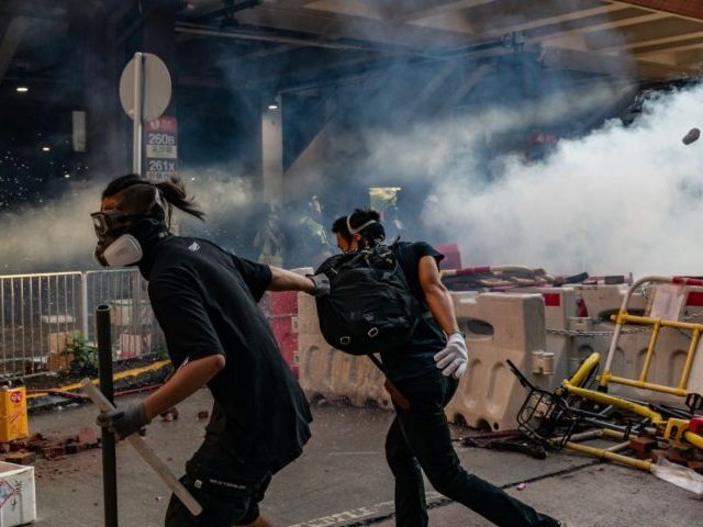 HONG KONG, CHINA - SEPTEMBER 21: Pro-democracy protesters run after police fired tear gas