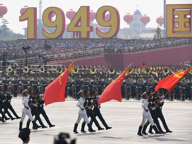 Chinese soldiers march with the national flag (C), flanked by the flags of the Communist Party of China (R) and the People's Liberation Army (L) during a military parade at Tiananmen Square in Beijing on October 1, 2019, to mark the 70th anniversary of the founding of the People's Republic …
