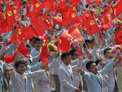 People wave Communist Party flags during a military parade in Tiananmen Square in Beijing on October 1, 2019, to mark the 70th anniversary of the founding of the People's Republic of China. (Photo by GREG BAKER / AFP) (Photo credit should read GREG BAKER/AFP/Getty Images)