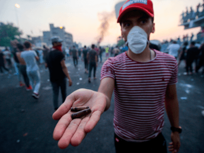An Iraqi protester displays bullet casings during a demonstration against state corruption