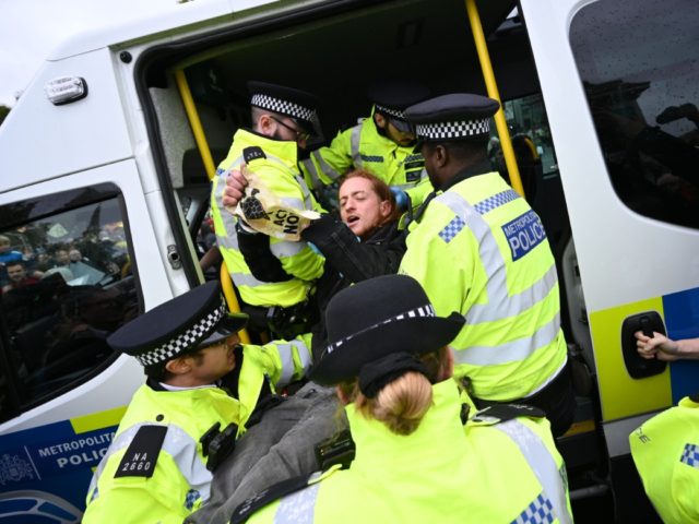 A climate change activist from the Extinction Rebellion group is arrested by police in Tra
