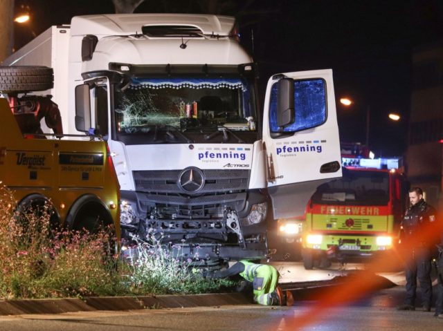 Police officers and firemen look on as a man inspects on early October 8, 2019 the truck that ploughed into several cars on late October 7 in the centre of the German city of Limburg. - The stolen truck ploughed into several cars leaving a number of people injured, police …