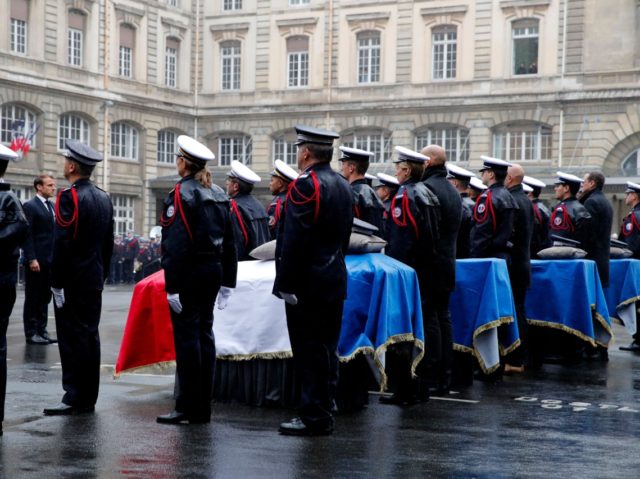 French President Emmanuel Macron (2L) takes part in a ceremony at The Prefecture de Police