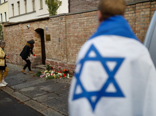 People lays flowers on October 10, 2019 at the synagogue in Halle, eastern Germany, one da