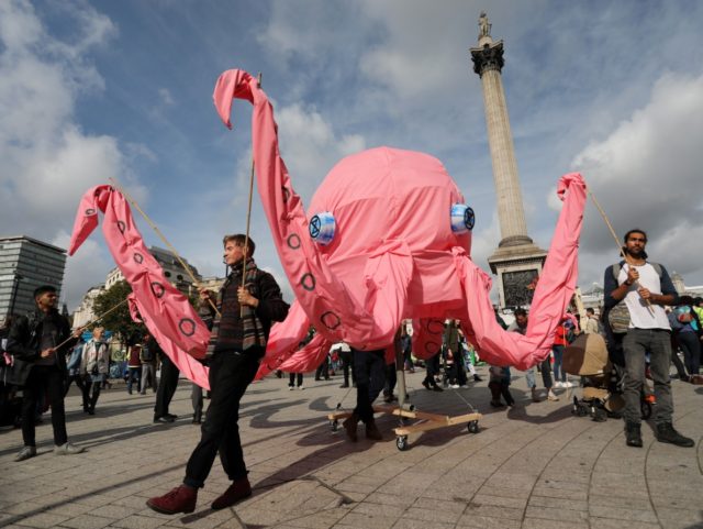 TOPSHOT - Activists walk with a giant pink octopus at Trafalgar Square during the fourth day of demonstrations by the climate change action group Extinction Rebellion, in London, on October 10, 2019. - Demonstrations occurred in 60 cities around the world this week, with thousands taking to the streets of …