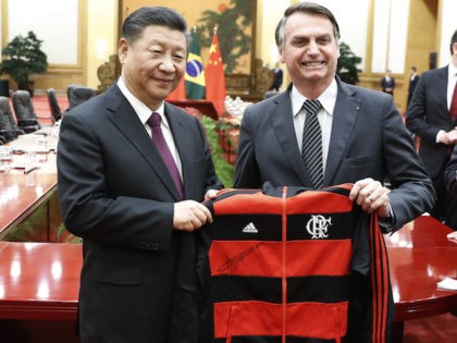 Brazil's President Jair Bolsonaro (R) gifts China's President Xi Jinping (L) a jacket at the end of the signing ceremony at the Great Hall of the People in Beijing on October 25, 2019. (Photo by Yukie Nishizawa / POOL / AFP) (Photo by YUKIE NISHIZAWA/POOL/AFP via Getty Images)