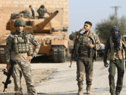 Turkish soldiers and a Turkey-backed Syrian fighter walk during a raid in a village east of Ras al-Ain on the border between Syria and Turkey in northeastern Syria, on October 28, 2019. (Photo by Nazeer Al-khatib / AFP) (Photo by NAZEER AL-KHATIB/AFP via Getty Images)