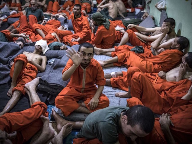 Men, suspected of being affiliated with the Islamic State (IS) group, gather in a prison cell in the northeastern Syrian city of Hasakeh on October 26, 2019. - Kurdish sources say around 12,000 IS fighters including Syrians, Iraqis as well as foreigners from 54 countries are being held in Kurdish-run …