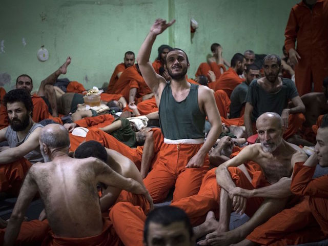 Men, suspected of being affiliated with the Islamic State (IS) group, gather in a prison cell in the northeastern Syrian city of Hasakeh on October 26, 2019. - Kurdish sources say around 12,000 IS fighters including Syrians, Iraqis as well as foreigners from 54 countries are being held in Kurdish-run prisons in northern Syria. (Photo by FADEL SENNA / AFP) (Photo by FADEL SENNA/AFP via Getty Images)