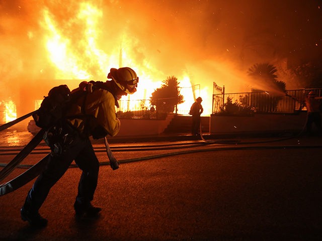 PORTER RANCH, CALIFORNIA - OCTOBER 11: Firefighters work at a house fire in the early morning hours during the Saddleridge Fire on October 11, 2019 in Porter Ranch, California. The fast-moving wind-driven fire has burned more than 4,000 acres and at least 23,000 homes are under mandatory evacuation orders. (Photo …