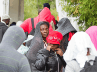 A long line of asylum seekers wait to illegally cross the Canada/US border near Champlain, New York on August 6, 2017. In recent days the number of people illegally crossing the border has grown into the hundreds. / AFP PHOTO / Geoff Robins (Photo credit should read GEOFF ROBINS/AFP/Getty Images)