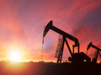 Pump jack silhouette against a sunset sky with deliberate lens flare and copy space. These jacks can extract between 5 to 40 litres of crude oil and water emulsion at each stroke. This image is made up of 2 photos attached here for reference--one is my image of an Alberta …
