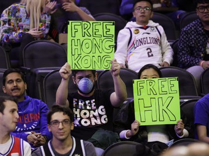 Fans hold signs ahead of a an NBA exhibition basketball game between the Philadelphia 76ers and the Guangzhou Loong-Lions on Tuesday, Oct. 8, 2019, in Philadelphia. (AP Photo/Matt Rourke)