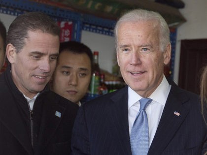 U.S. Vice President Joe Biden, center, buys an ice-cream at a shop as he tours a Hutong alley with his granddaughter Finnegan Biden, right, and son Hunter Biden, left, in Beijing, China Thursday, Dec. 5, 2013. (AP Photo/Andy Wong, Pool)