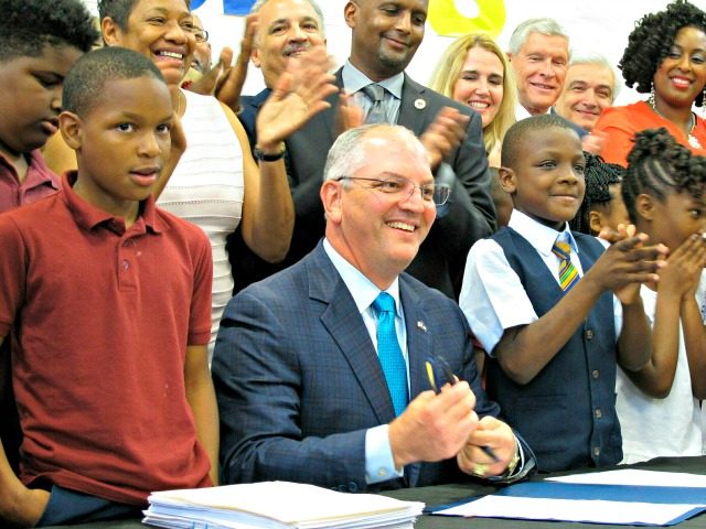 In this June 18, 2019, file photo, Gov. John Bel Edwards signs the Louisiana state operating budget for the upcoming year during a visit to Capitol Elementary School in Baton Rouge, La. A Republican group has responded to the start of Louisiana Gov. John Bel Edwards’ TV campaign for re-election …