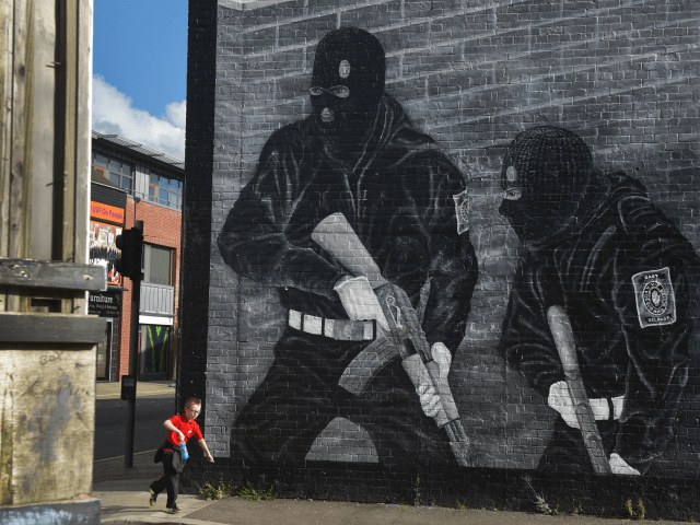 BELFAST, NORTHERN IRELAND - OCTOBER 13: A young boy runs past a loyalist paramilitary mura