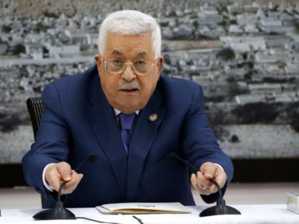 Palestinian President Mahmoud Abbas fixes the microphones during a meeting with the Palest