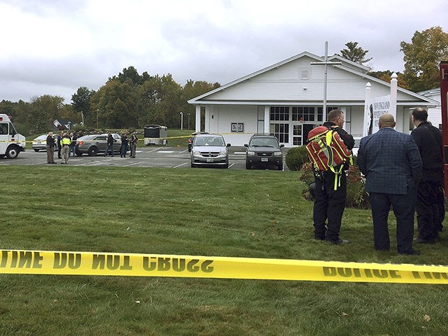 In this photo provided by WMUR-TV, police stand outside the New England Pentecostal Church after reports of a shooting on Saturday, Oct. 12, 2019, in Pelham, N.H. WMUR-TV reports that Hillsborough County Attorney Michael Conlon said a suspect is in custody. (Siobhan Lopez/WMUR-TV via AP)