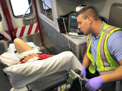 An Illinois firefighter treats an overdose victim as she is transported to a hospital.